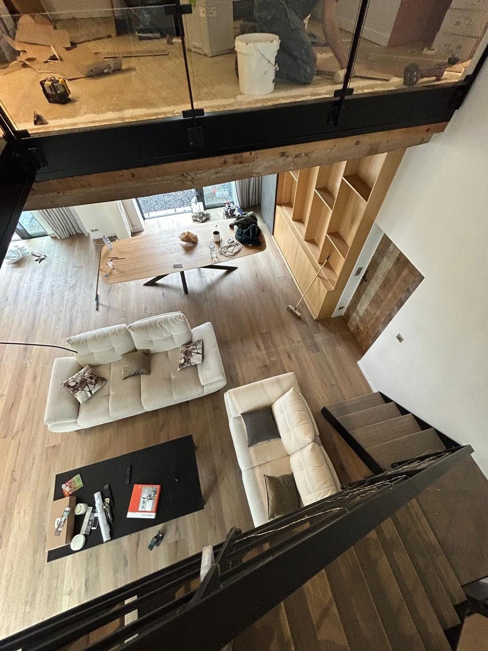 Vue depuis la mezzanine – parquet posé au rez-de-chaussée, chantier en cours à l'étage