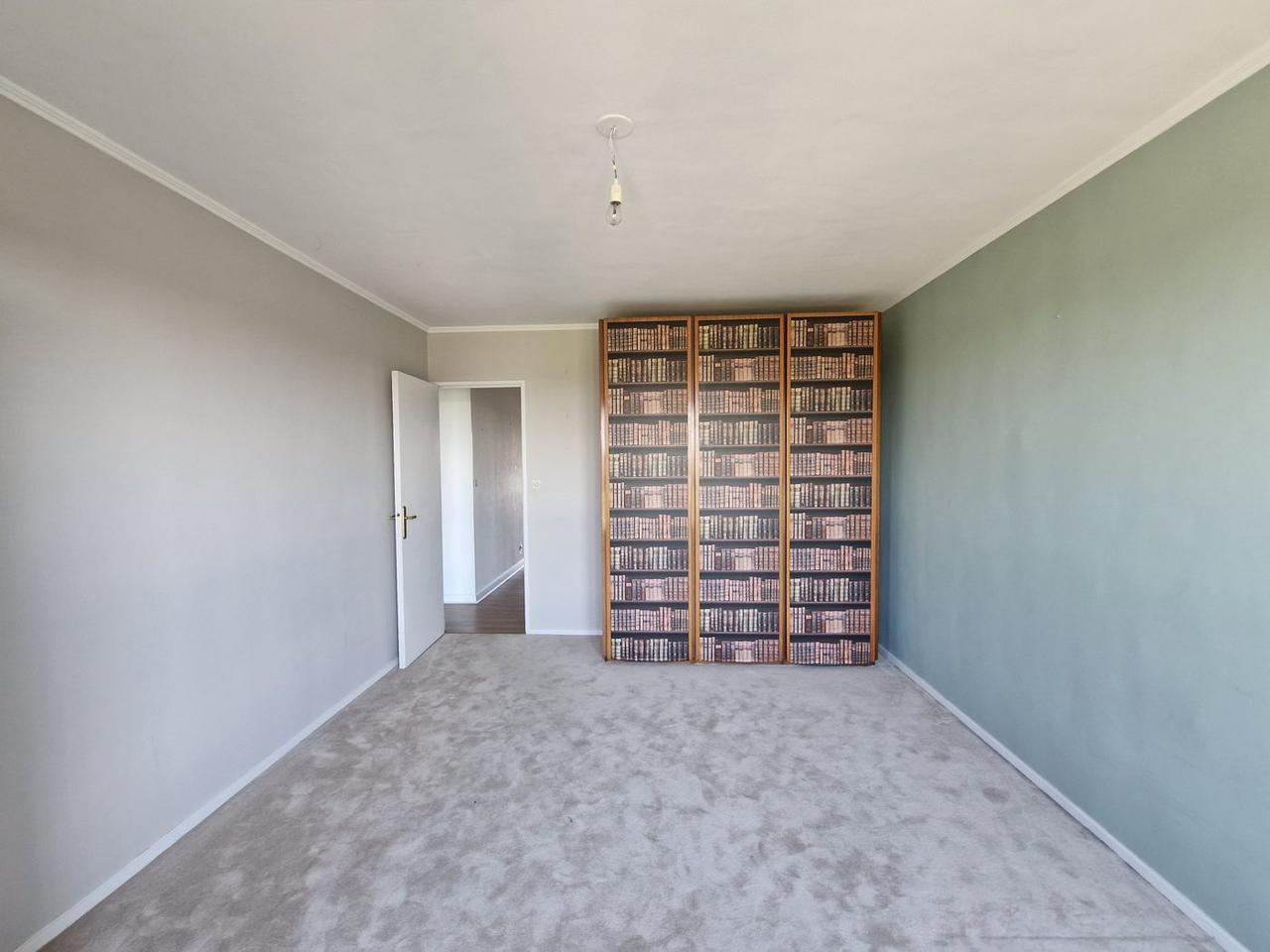 Chambre avant travaux – moquette grise et bibliothèque