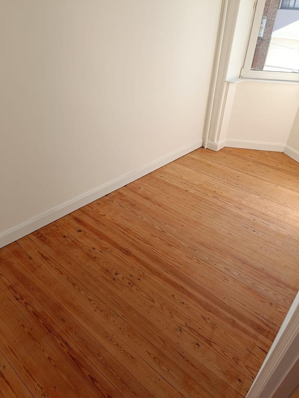 Angle de chambre – parquet poncé et plinthes blanches