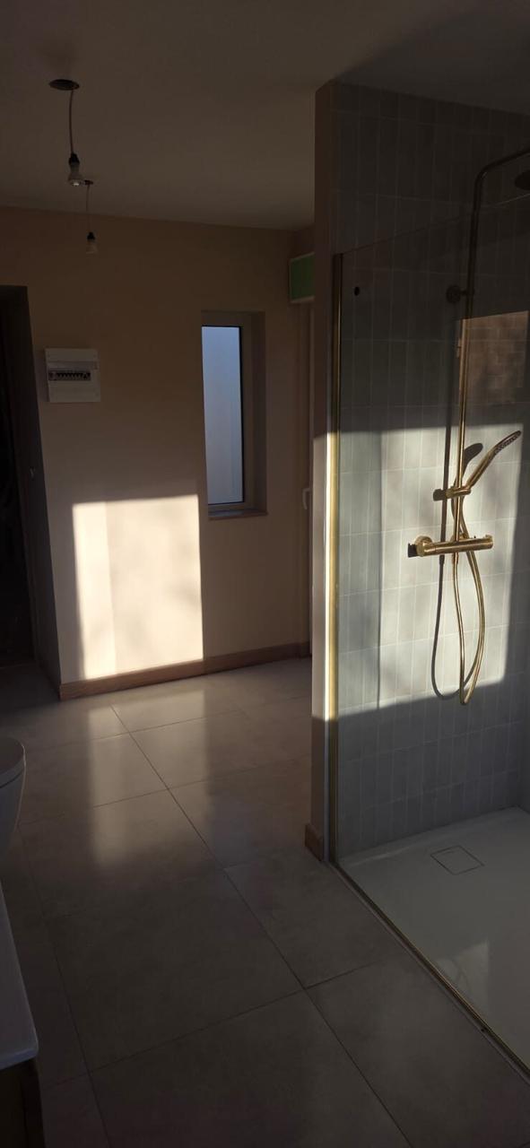 Salle de bain terminée – douche à l'italienne, robinetterie dorée