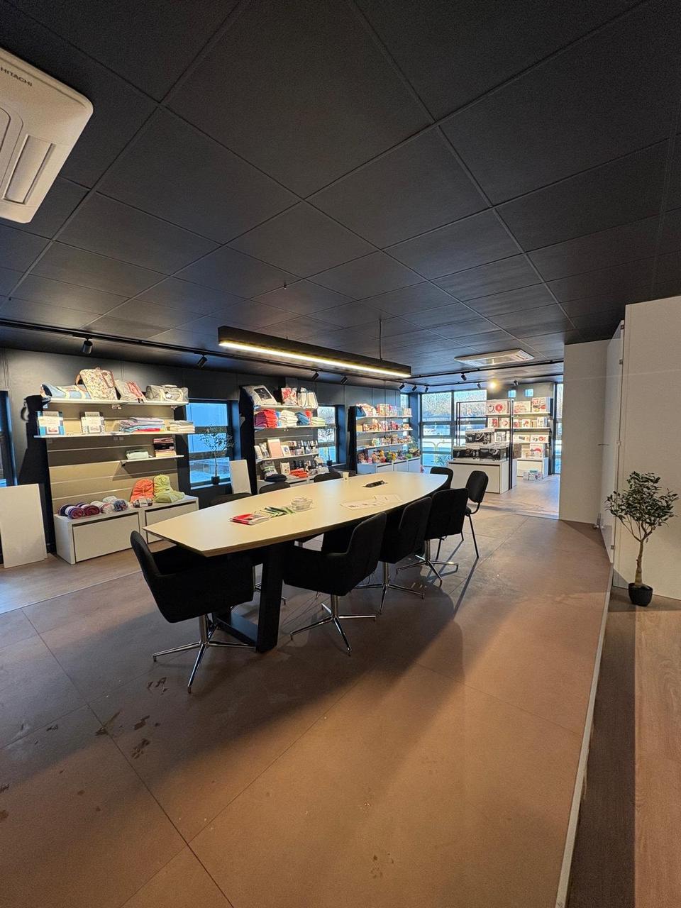Espace réunion – grande table et rayonnages produits