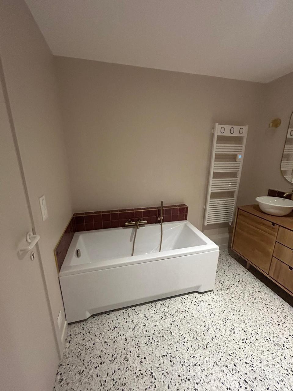 Baignoire encastrée – carrelage bordeaux et robinetterie dorée