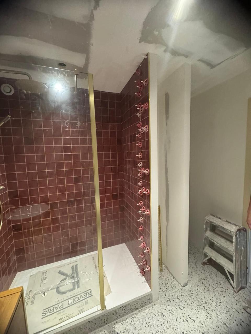 Douche zellige bordeaux – paroi et profilé doré